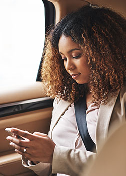 Young woman using phone in car