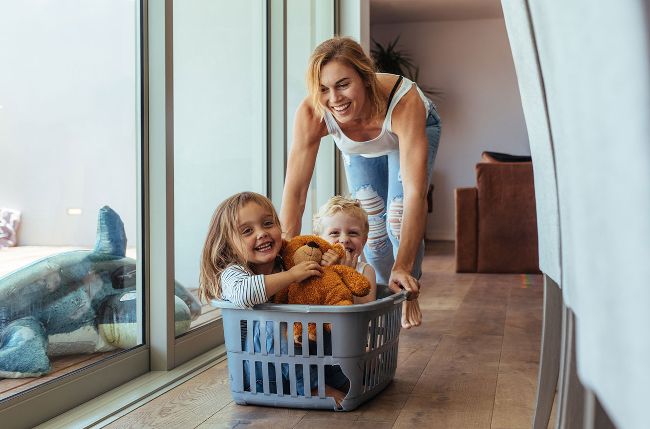 Mom pushing kids around in laundry basket