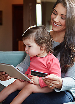 Woman and son using tablet on couch