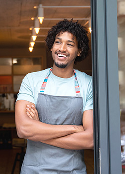 Businessman leaning in shop doorway