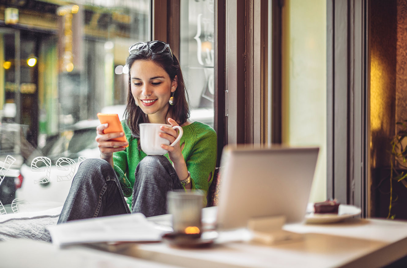 Young woman using phone in a coffee shop