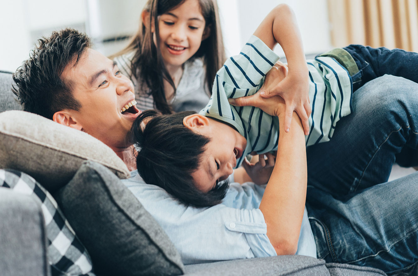 Father and kids playing on couch