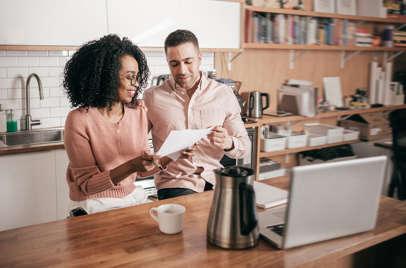 Husband and wife going over finances in kitchen